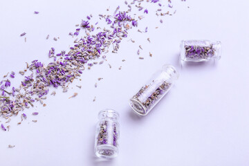 Bottles with lavender flowers on color background