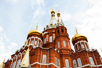 Fototapeta na wymiar Beautiful red brick cathedral with golden domes