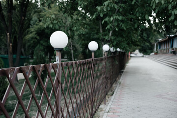 Row of   street lights   and a metal fence
