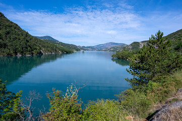 Fototapeta na wymiar Paysage du lac de Serre-Ponçon entouré de montagne dans le département des Alpes-de-Haute-Provence en France en été