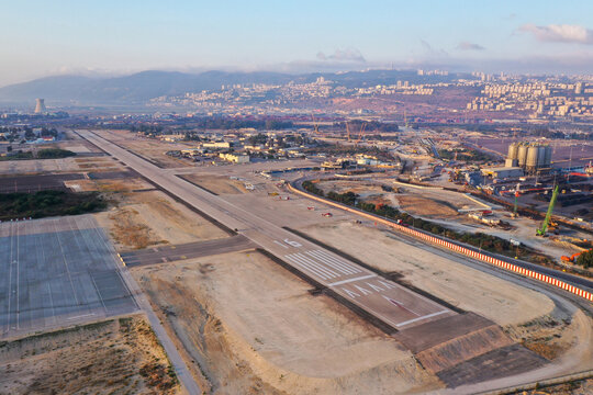 Haifa airport and runway with the city skyline in the background, Aerial view.