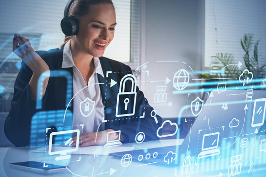 Businesswoman wearing formal suit is sitting at workplace in front of laptop, blue glowing information protection icons. Padlock and interface. Concept of cyber security and data storage