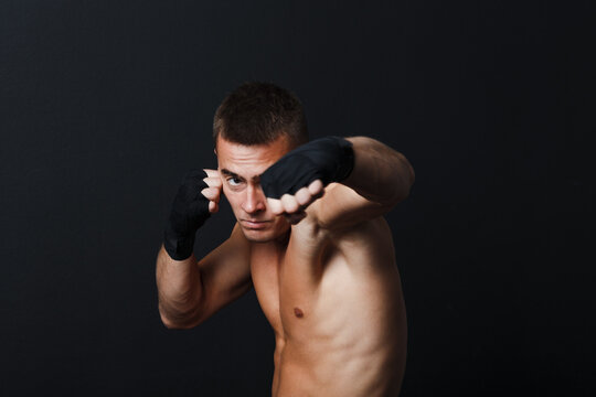 Sportsman muay thai man boxer stance at black background.