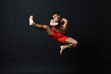 Obraz na płótnie Canvas Sportsman muay thai man boxer stance at black background.
