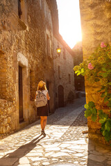 A young tourist walking in Pals medieval town, streets of the historic center at sunset, Girona on the Costa Brava of Catalonia in the Mediterranean