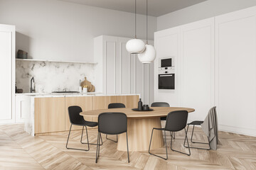 Corner of white kitchen with marble splashback and dining table