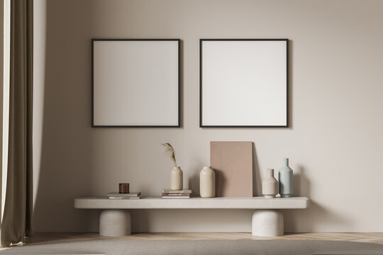 Two square posters with a bench near a beige living room wall