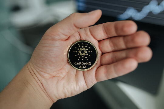 Cardano Ada cryptocurrency coin held in hand close-up