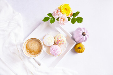 Fototapeta na wymiar Cup of coffee, pink pumpkins, roses bouquet, cupcakes on the white background. Feminine atmosphere. Woman power. Happy Halloween. Girlish fall composition. Coffee break at home. Holiday girly concept.