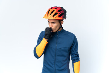 Young cyclist man isolated on background having doubts
