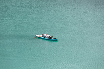 The girl is sunbathing on a sapa on a pond with turquoise water