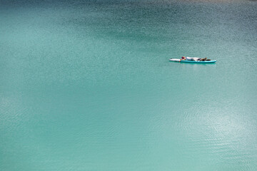 The girl is sunbathing on a sapa on a pond with turquoise water