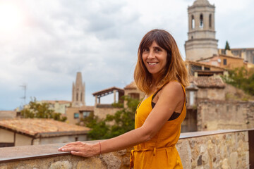 Girona medieval city, a young tourist looking at the city from a viewpoint of the historic center, Costa Brava of Catalonia in the Mediterranean. Spain