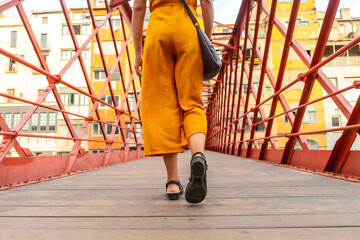 Obraz premium Girona medieval city, a young tourist walking on the famous red bridge Pont de les Peixateries Velles, Costa Brava of Catalonia