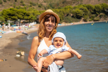 Fototapeta na wymiar Mother with her baby in Cala Montjoi, beach of the Cap Creus Natural Park, Gerona, Costa Brava of Catalonia in the Mediterranean. Spain