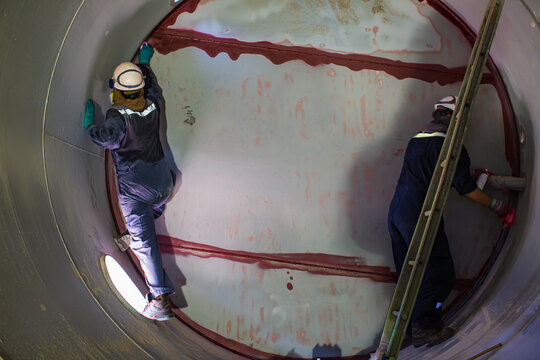 Working male two inspection weld PT test weldment for finding defect  underground of tank equipment tunnel By using the flashlight in side confined