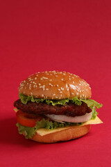 Hamburger in a vertical format placed on a red background.