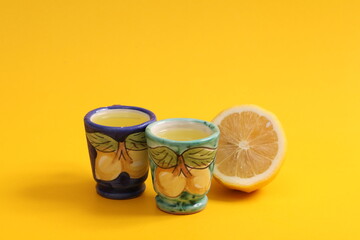 2 cups of Limoncello on yellow background.