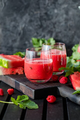 Summer drink. Cold watermelon juice with lime and mint on a wooden board. Berry-fruit smoothie.