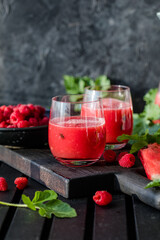 Summer drink. Cold watermelon juice with lime and mint on a wooden board. Berry-fruit smoothie.