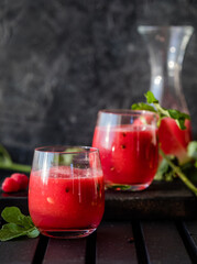 Summer drink. Cold watermelon juice with lime and mint on a wooden board. Berry-fruit smoothie.