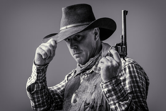 American cowboy. Cowboy wearing hat. Western life. Guy in cowboy hat. American bandit in mask, western man with hat. Man wearing cowboy hat, gun. West, guns. Portrait of a cowboy