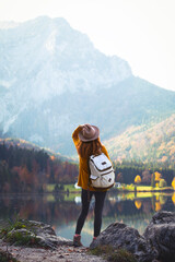 girl stands on the shore of a mountain lake