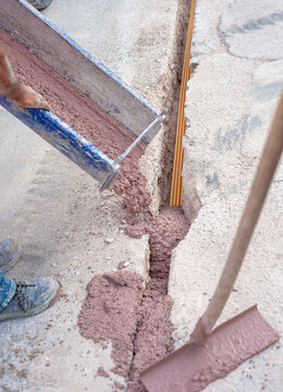 Filling with colored concrete of excavation with a narrow section for the implementation of a fiber optic distribution network for telecommunications.