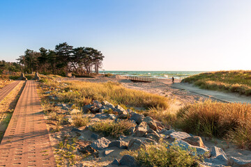 .Bicycle path along the coast of the Baltic Sea, a beautiful sunset over a sandy beach, dunes,...
