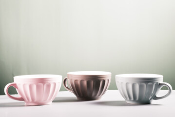 three cute empty ceramic coffee cups pastel colors and rowan branch