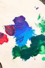 mixed on a wooden palette of multi-colored paints