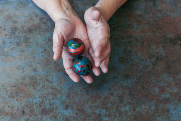 hands of senior adult woman excercising with chinese baoding balls for stress relief and deep...