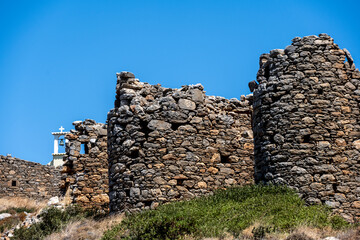 ancient stone mills and their ruins on the slopes of the mountains in Crete on a sunny day