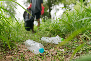 Boy man hand pick up plastic bottle in the forest. nature conservation and Environment concept.