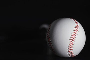 American traditional sports game. Baseball. Concept. Baseball ball and bats on a black table.