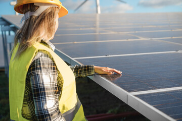 Engineer woman working at alternative energy farm - Focus on hand over solar panel
