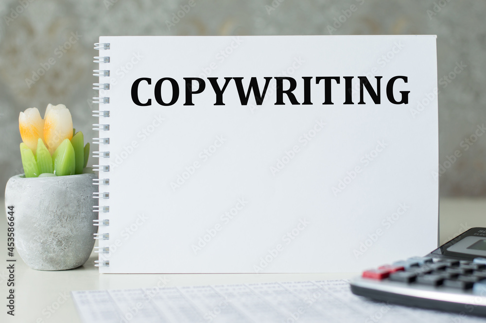 Poster copywriting text on a notebook that stands on the table next to the calculator, financial statements