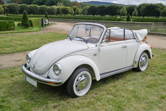 HOLESOV, CZECH REPUBLIC - AUGUST 29, 2021: White VW Beetle 1303 cabriolet parked in a garden. VW beetle is an economy car that was manufactured by Volkswagen from 1938 until 2003.