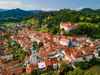 Fototapeta na wymiar Skofja Loka Cityscape and Medieval Loka Castle in Slovenia. Aerial Drone View