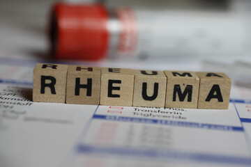 Viersen, Germany - June 1. 2021: Closeup of word rheuma on laboratory requisition slip with syringe...
