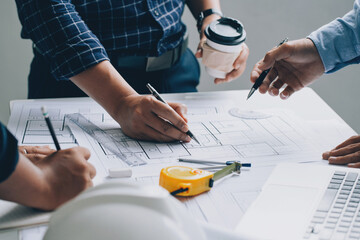 Engineer or architect meeting for project working with partner and checks construction blueprints...