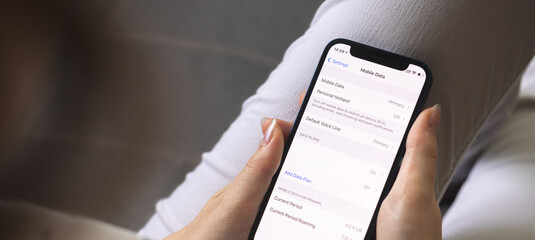 Woman switches mobile data on mobile phone. Cellular data screen and settings on the screen...
