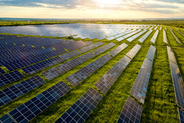 Aerial view of large sustainable electrical power plant with many rows of solar photovoltaic panels...