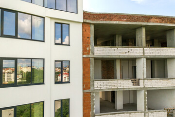 Many windows on new apartment building facade under construction.