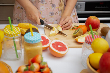Obraz na płótnie Canvas Happy woman enjoy preparing freshly squeezed fruits with vegetables for making smoothies for breakfast together in the kitchen.diet and Health concept.