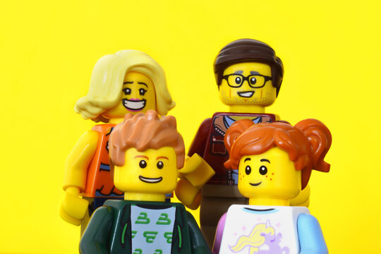 Editorial illustartive image of lego minifigures of father, mother, daughter and son. Happy smiling family on yellow background.