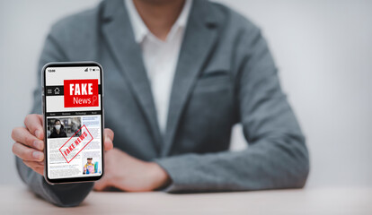 Fake News online on smartphone concept, businessman reading Fake news or articles about covid-19 in a smartphone screen application, media technology ,Online fake news on a mobile phone or computers.