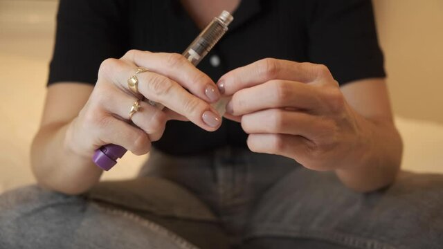 lady Preparing syringe pen for Hormone therapy treatment, Egg freezing. doing mature oocyte cryopreservation, FSH  stimulate the ovaries to produce more eggs, initial process fertility treatment. 