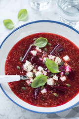 Close-up of beetroot soup with addition of quinoa and bryndza cheese, vertical shot, selective focus