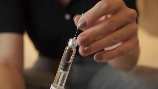 Lady preparing syringe pen for Hormone therapy treatment, Egg freezing, mature oocyte cryopreservation, FSH to stimulate the ovaries to produce more eggs, initial process for fertility treatment. 